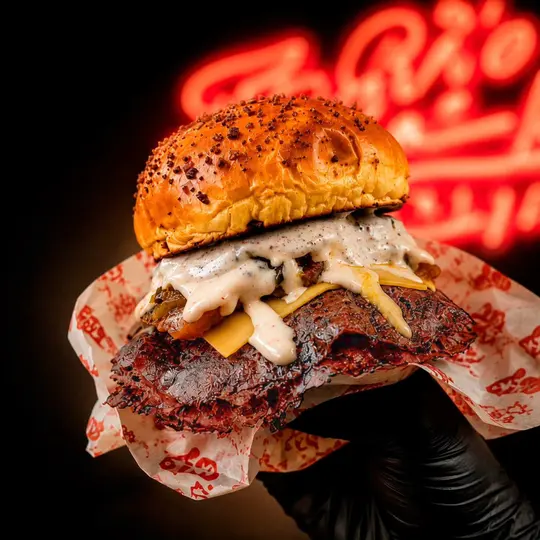 Burger sobre pan brioche especiado, servida en papel